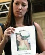 Una mujer muestra la foto de una amiga desaparecida desde el 7-J.