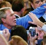 George W. Bush saluda a un grupo de seguidores durante un mitin.