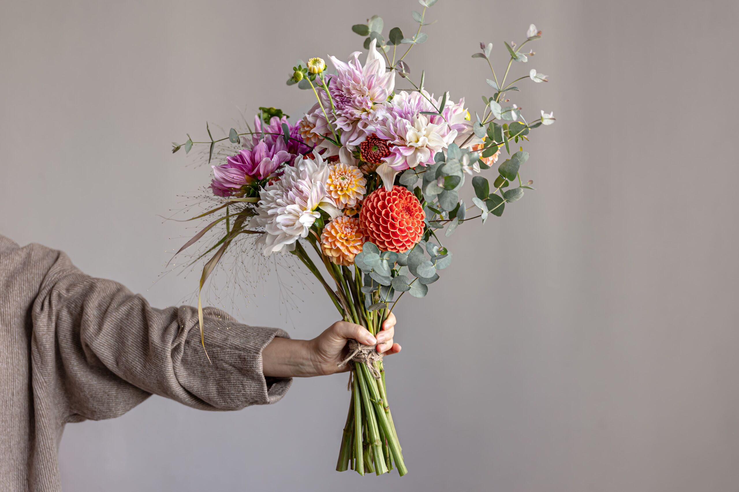 woman-holds-her-hand-festive-flower-arrangement-with-bright-chrysanthemum-flowers-festive-bouquet-1.jpg